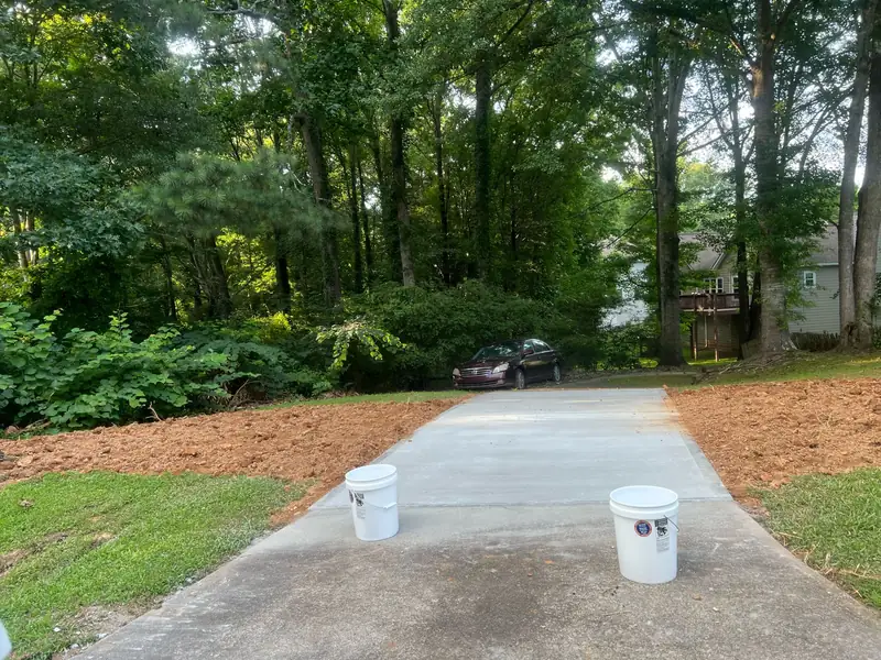 Long new concrete driveway through a wooded lot