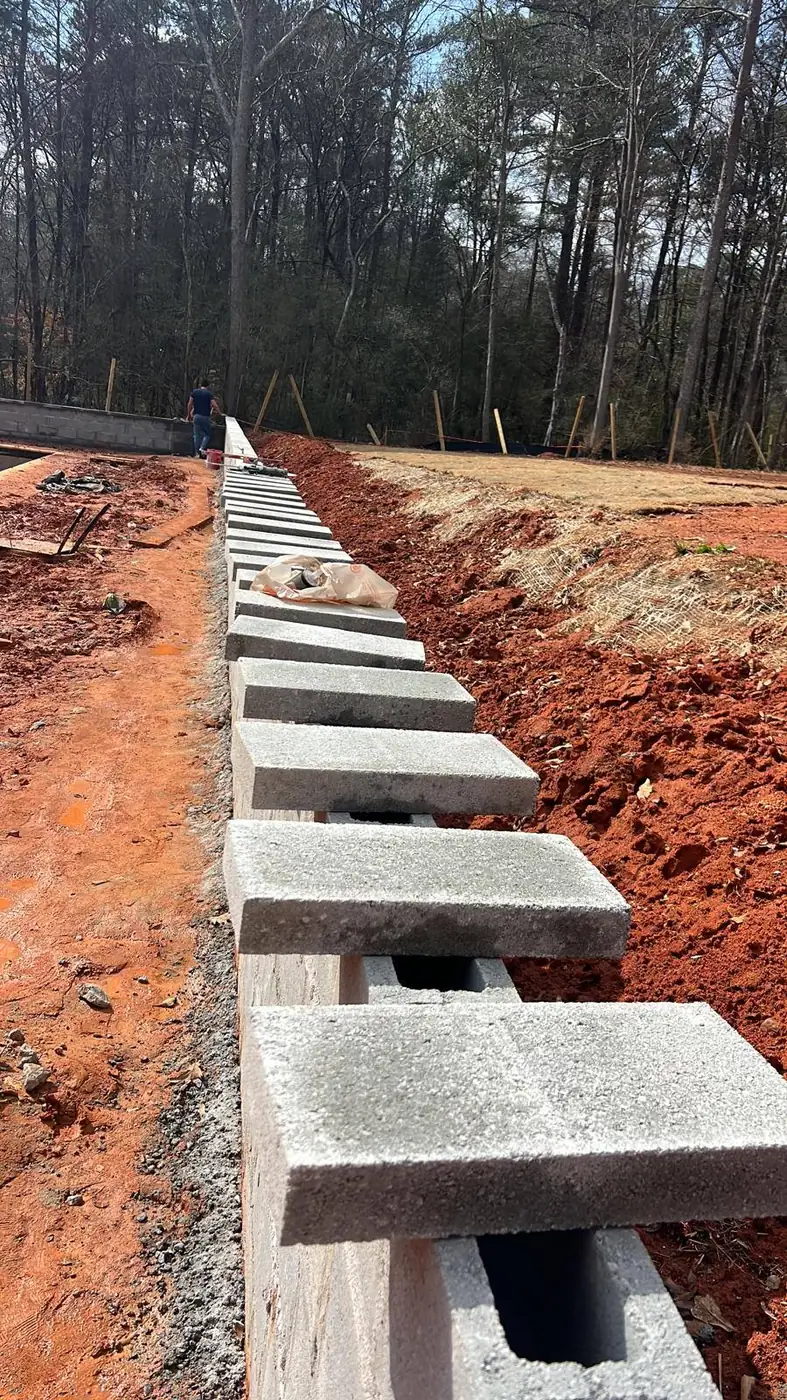 First course of concrete block set on a fresh footing