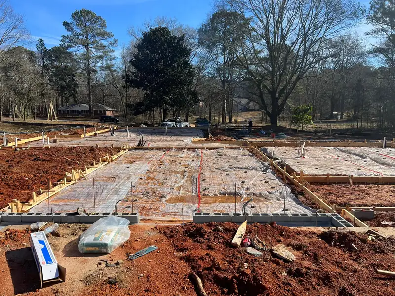 Formed concrete slab with a rebar grid on red clay